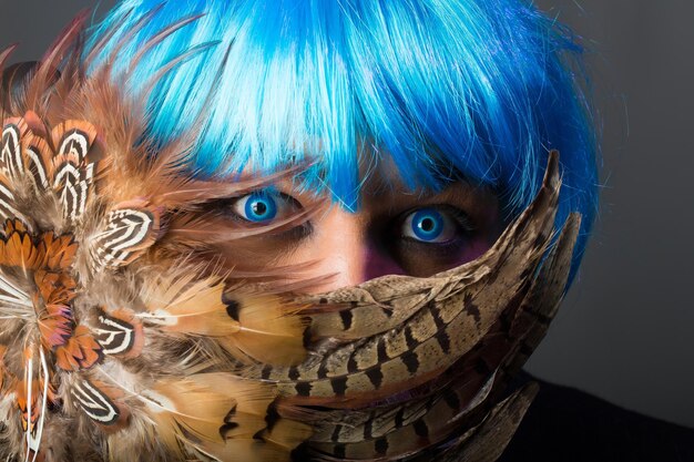 A detailed close-up of a cosplayer dressed as Jinx from Wild Rift. The costume features vibrant colors, meticulous attention to detail, and accurate weapon replicas. The cosplayer is posing confidently with a mischievous grin.