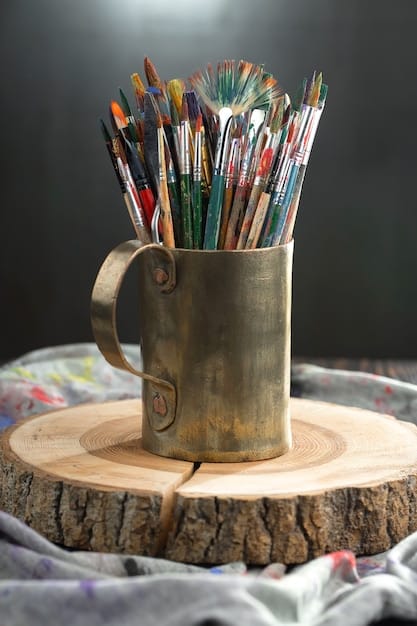 A close-up photograph of various traditional art supplies, such as paintbrushes, colored pencils, and drawing paper, arranged artistically on a wooden table. Soft, natural light highlights the textures and colors of the supplies.