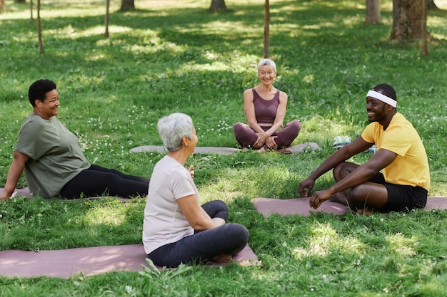 A diverse group of people of varying ages and body types participating in an outdoor community yoga class in a US park, symbolizing inclusivity and wellness.