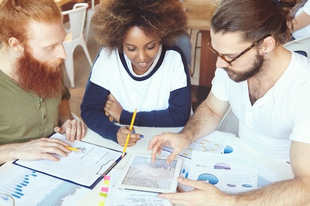 A diverse group of people discussing financial documents and charts around a table, highlighting financial literacy and collaborative investment planning.